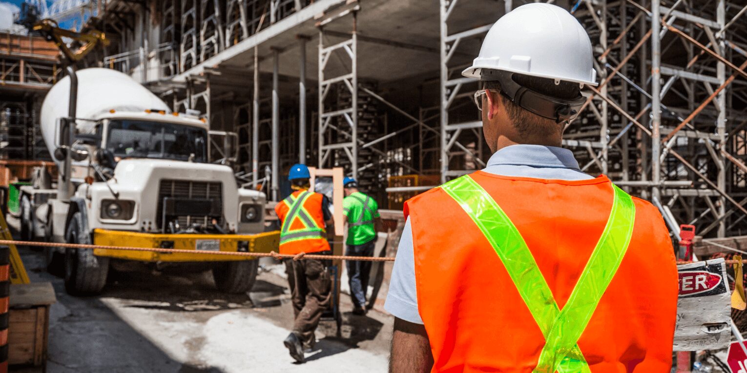 Crew leader with back turned overlooking a commercial construction project